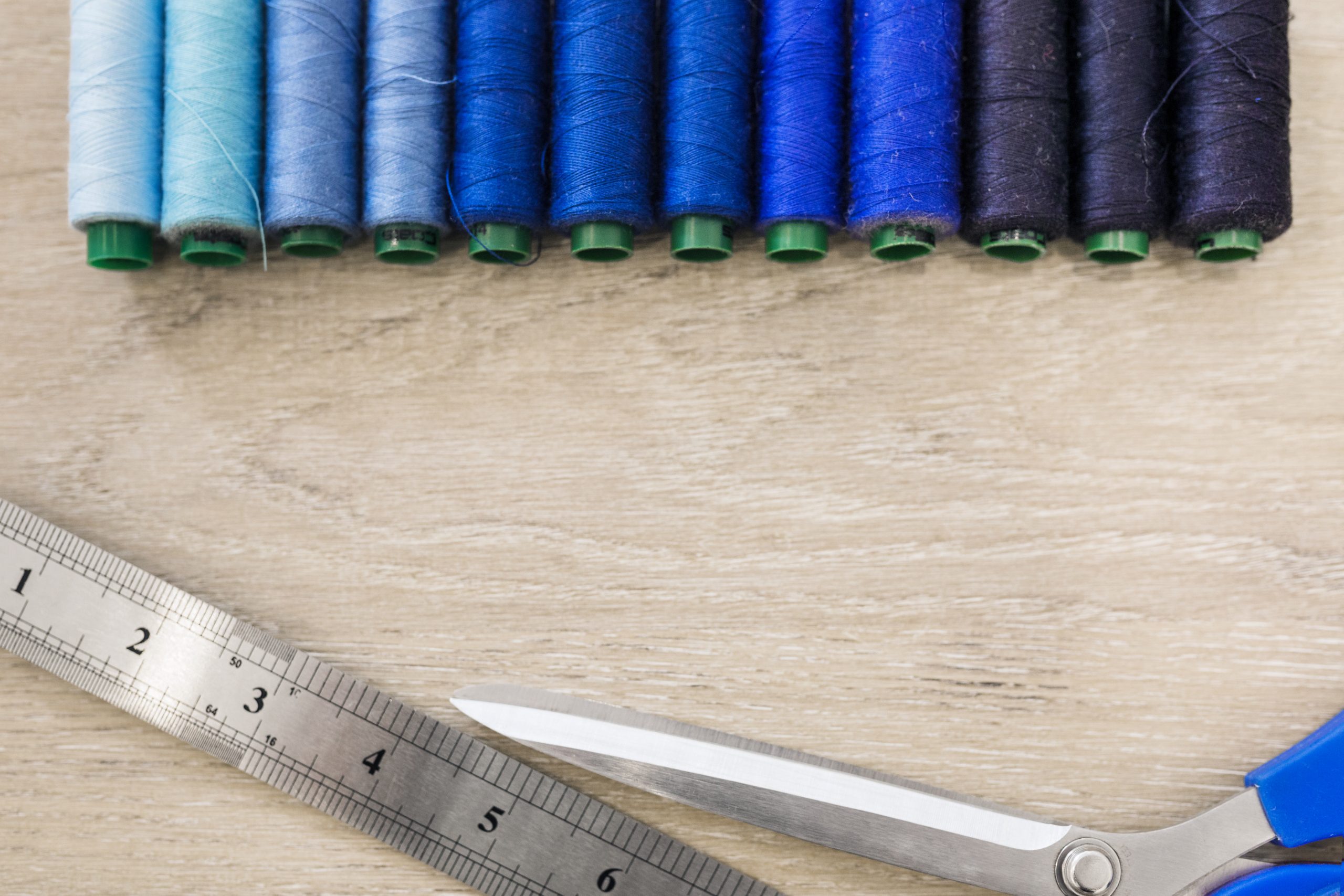 elevated-view-threads-scissors-scale-wooden-backdrop