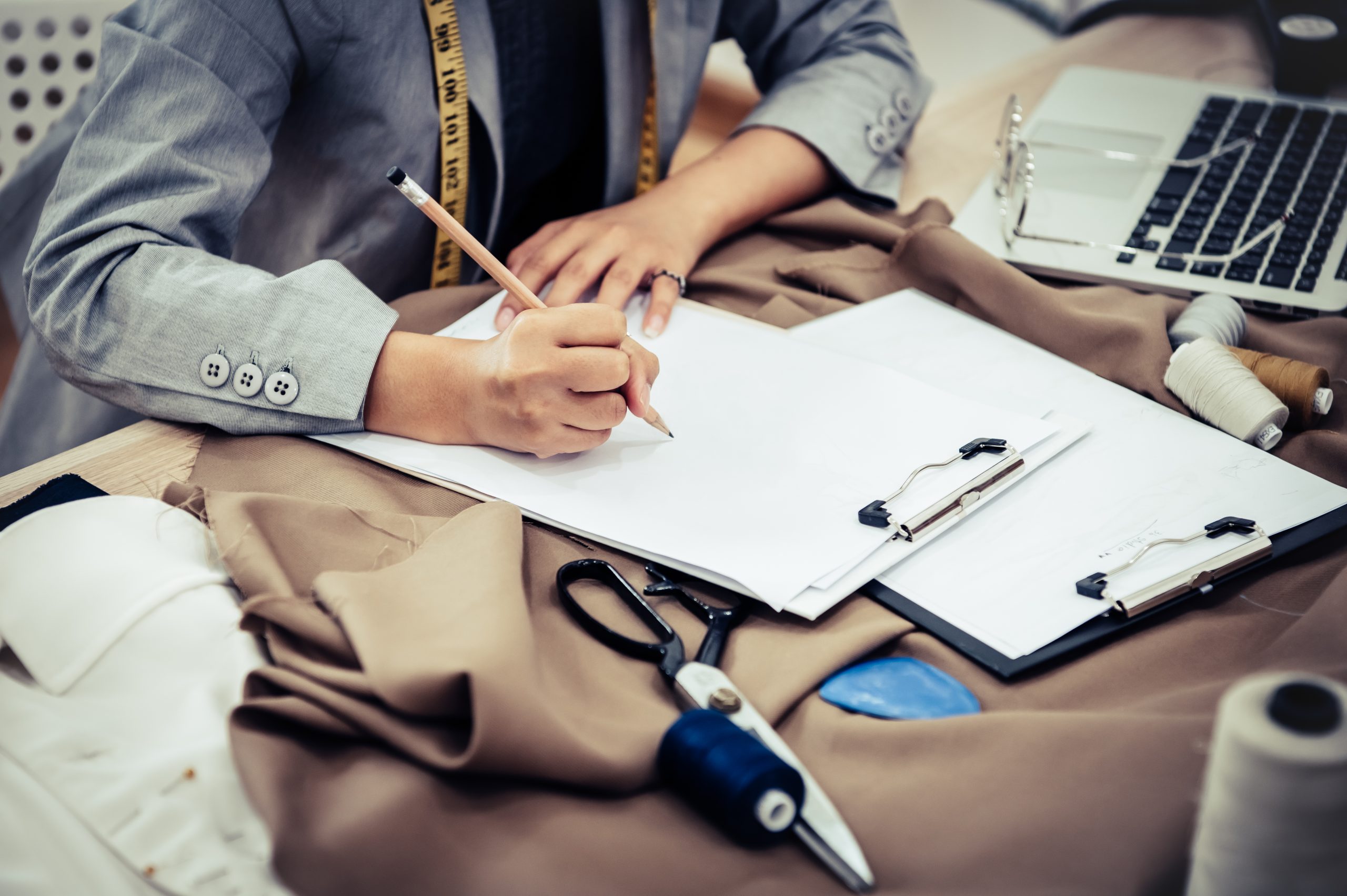 Closeup of attractive female fashion designer hand working in ho